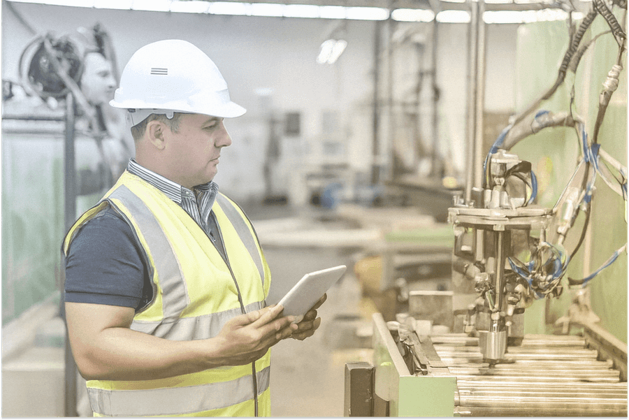Ein Mitarbeiter an der Maschine mit Tablet Ein Mitarbeiter an der Maschine mit Tablet